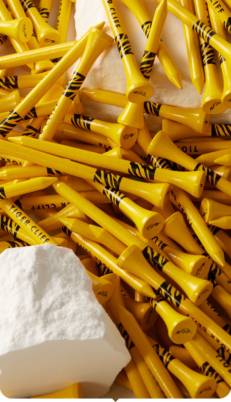 Stack of yellow golf tees with black text on a white background