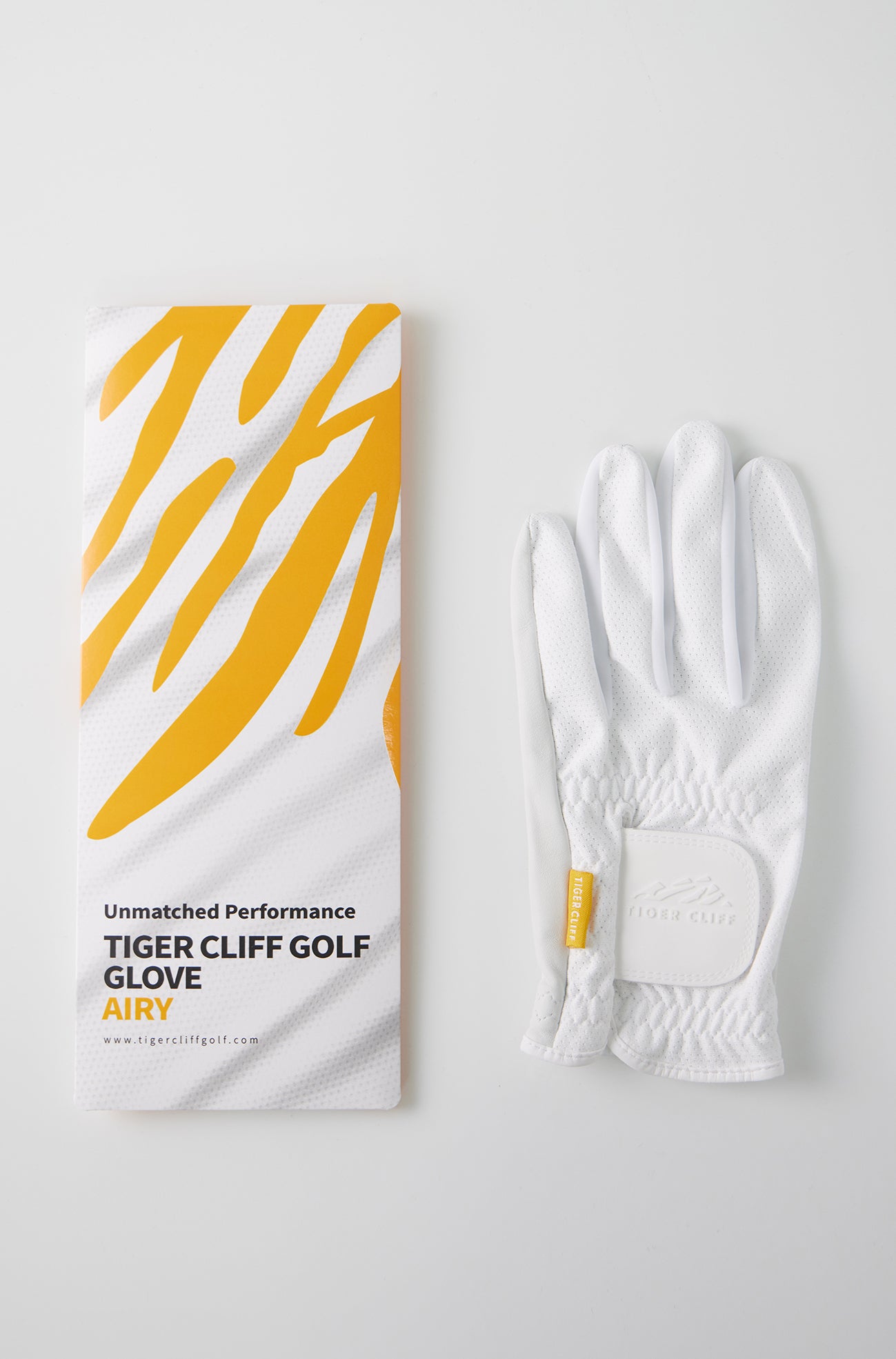 AIRY Tiger Cliff Golf Glove with packaging. White glove on a white background.