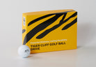 Yellow box of Tiger Cliff golf balls with a white golf ball on a light gray background