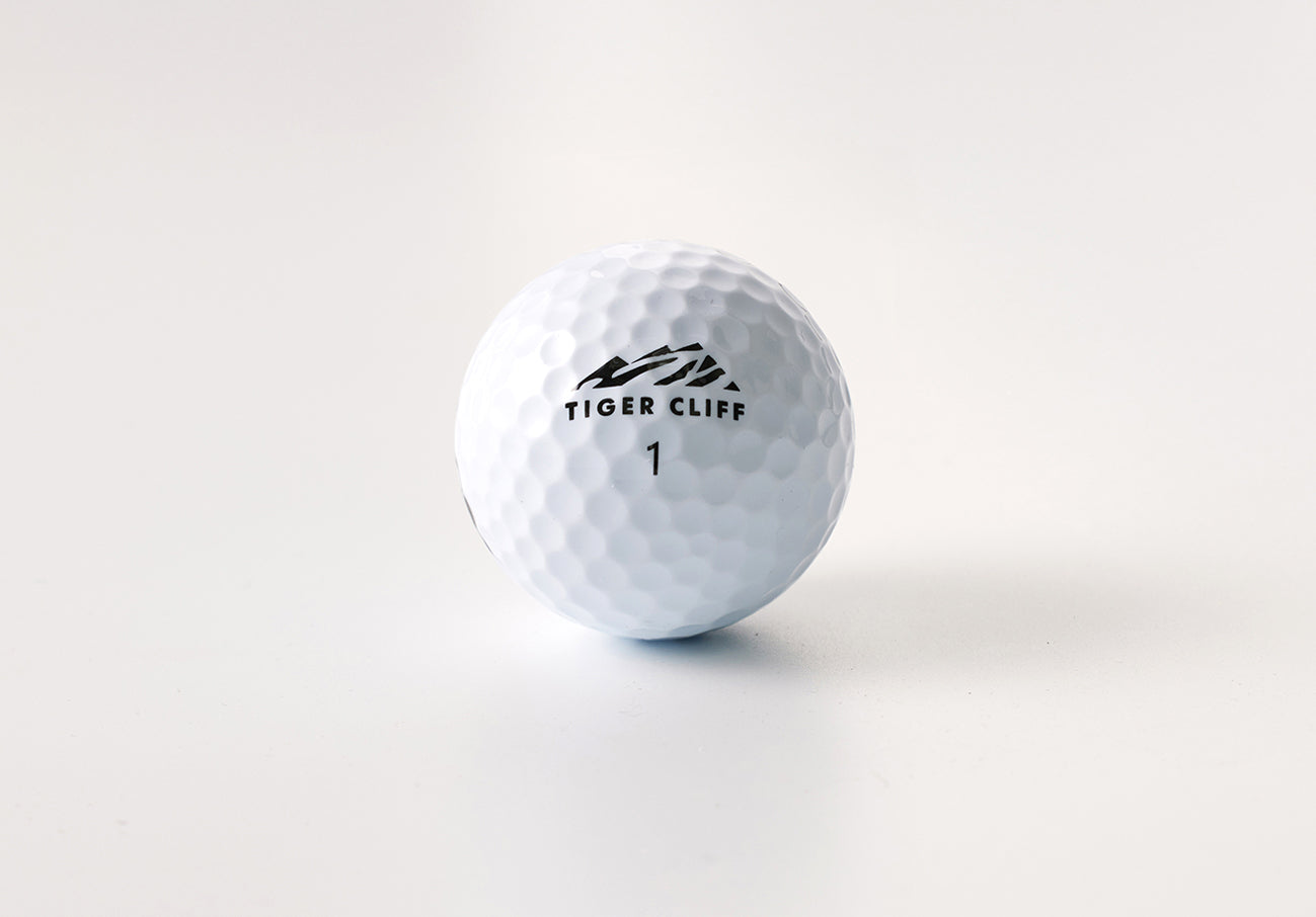 White Tiger Cliff golf ball, number 1, on a white surface.