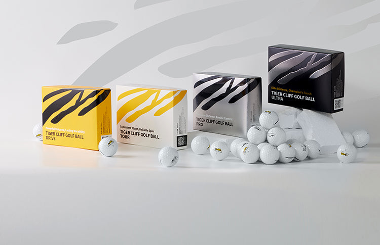 Boxes of Tiger Cliff golf balls: Drive, Tour, Pro, Ultra. Golf balls scattered around.