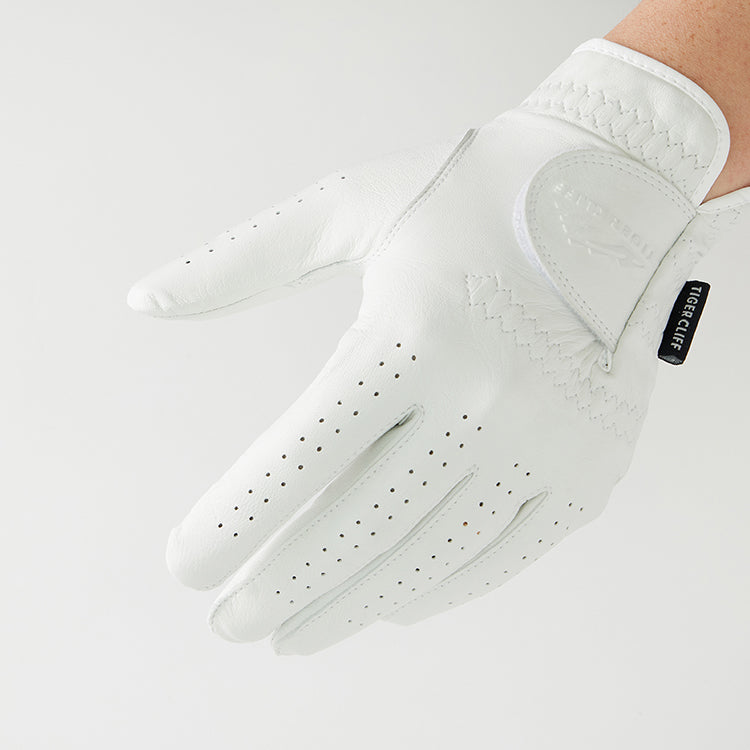 Close-up of a hand wearing a white, perforated Tiger Cliff Gloves - Lambskin.