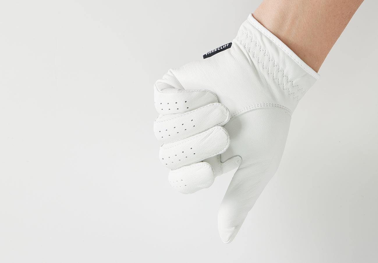 Hand wearing white LAMBSKIN glove giving a thumbs-down gesture.