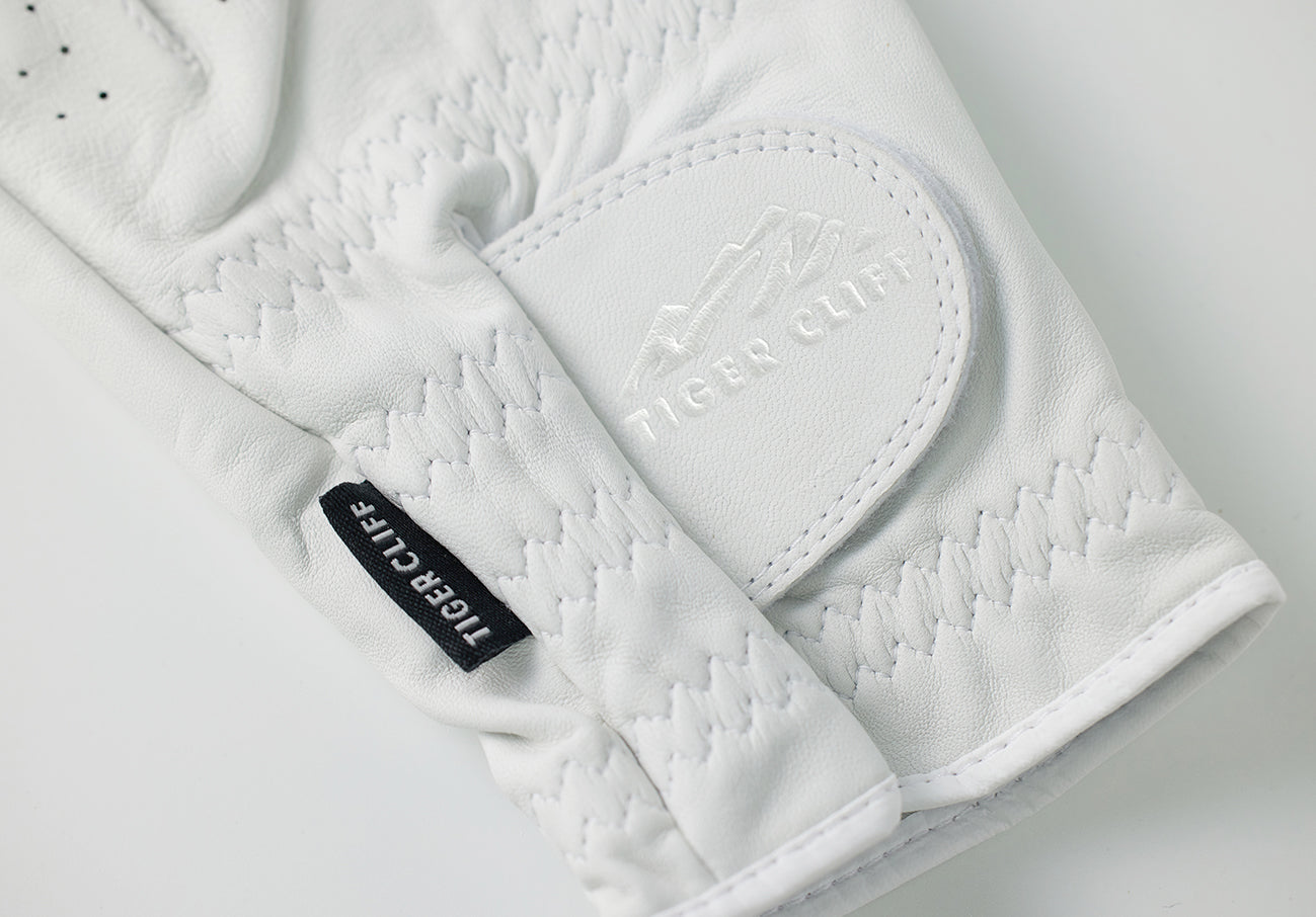 Close-up of white Tiger Cliff golf glove showing logo detail.