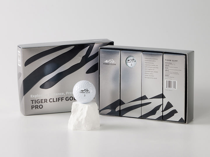 Tiger Cliff Pro golf ball on a rock with packaging.