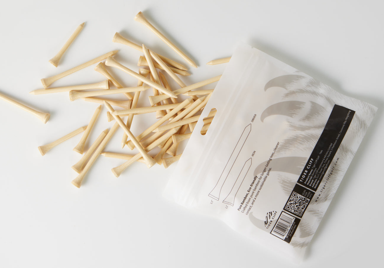 Tiger Cliff golf tees spill from their package on white.